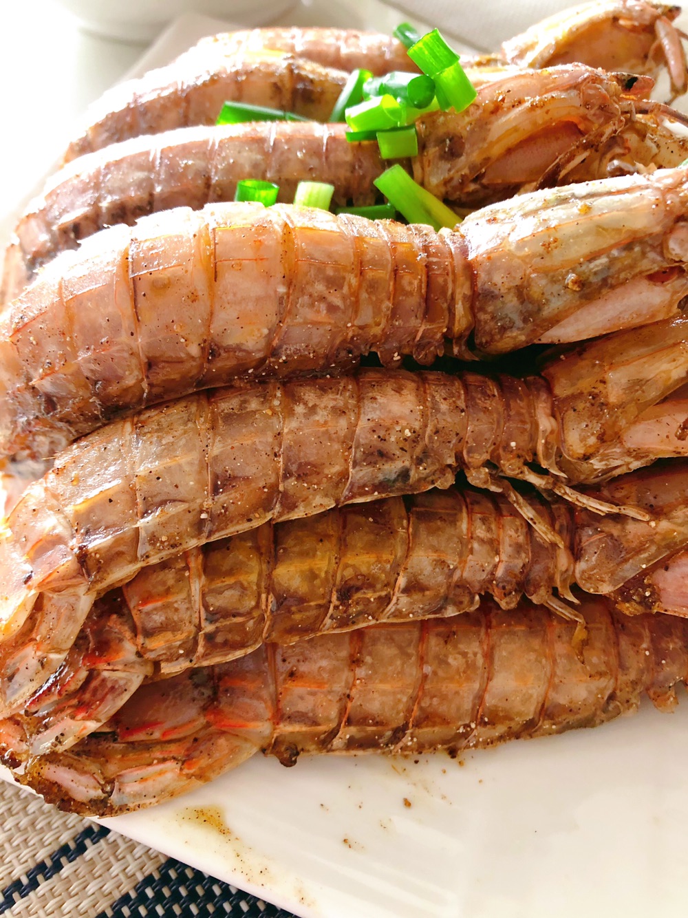 另起油锅,放少许油,姜蒜爆香,加入炸好的去皮皮虾,略微翻炒下,撒入黑