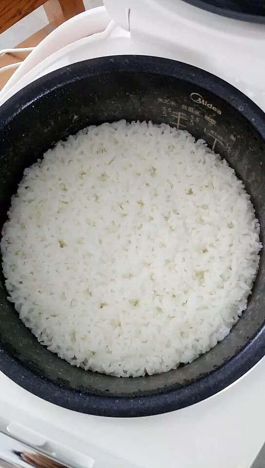 大米洗净放入美的电饭煲煮熟