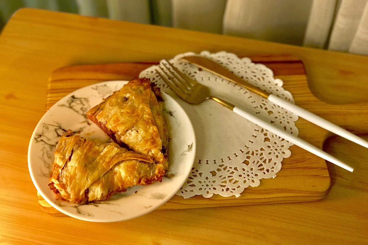 Hand grasping cake quick food - purple potato crispy with thousands of layers