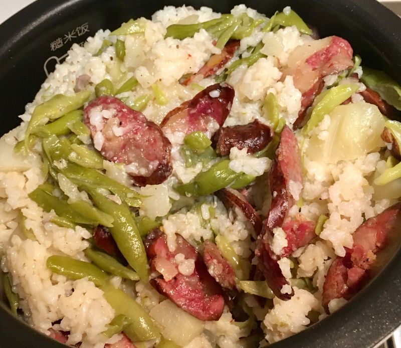 Making rice with bean and sausage and potato in electric rice pot