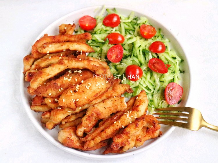 孩子爱吃家门口的炸鸡柳，为了他能吃得更健康，妈妈亲手做了更健康的煎鸡柳来满足他。孩子吃了好多哦！做法也很简单，鸡胸肉切成条，用葱姜蒜、黑胡椒和料酒腌制去腥，裹上炸鸡粉后放不粘锅里煎至两面金黄就好啦！图1