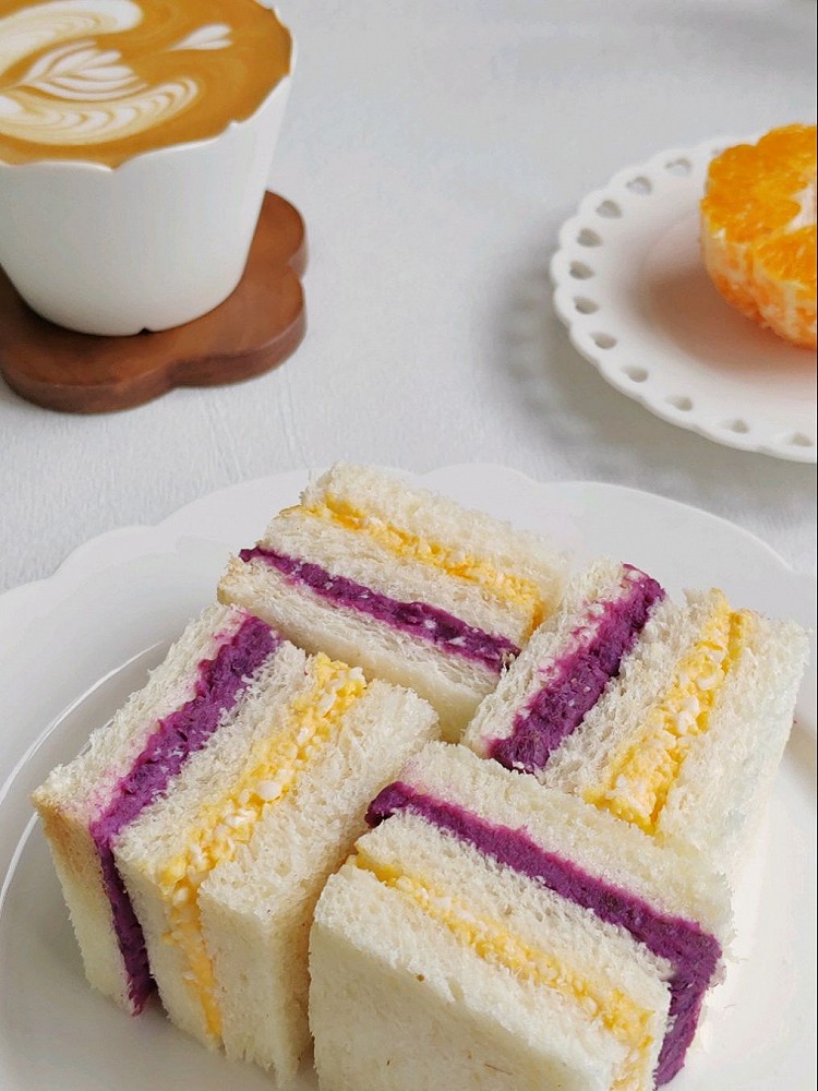 早餐𓎩𓌉𓇋 ‎：☆紫薯鸡蛋三明治🥪☆耙耙柑🍊☆咖啡☕🍭紫薯蒸熟加入少量牛奶压成紫薯泥，鸡蛋加入少量沙拉酱压碎，吐司分别放上紫薯泥和鸡蛋碎，用保鲜膜包紧（要包紧不然容易散）切成四片即可图6