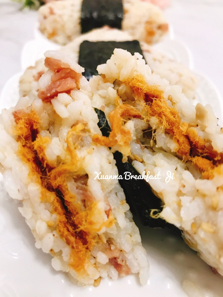 👩🏻‍🍳简单又好吃的培根肉松饭团🍙，将米饭换着花样吃，中间夹了大人小孩都爱吃的肉松，大大的吃一口超满足～┈┈┈┈┈┈┈分割线┈┈┈┈┈┈┈┈👩🏻‍🍳食材：1大碗米饭 培根3片 香菇2朵 生抽 海苔 肉松 熟芝麻1️⃣香菇和培根切切粒状，热锅放少许油，加入香菇和培根粒炒熟，加入少许生抽调味2️⃣炒好的香菇和培根粒倒入米饭里搅拌均匀，再加入少许熟芝麻和肉松搅拌均匀3️⃣拌好的米饭用保鲜膜包住压出三角造图6