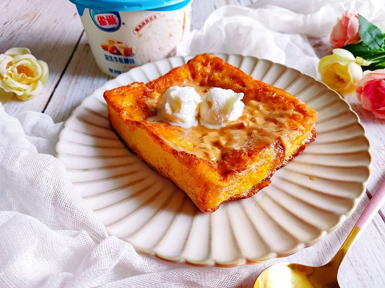 巨软巨香，特别好吃。厚吐司去掉四边，裹满蛋液，煎至两面金黄，四个边也竖起来煎一下，涂上一层花生酱，挖两勺冰淇淋，雀巢花生牛轧味冰淇淋里面还有花生颗粒，香香脆脆的，真的像在吃牛轧糖。图2