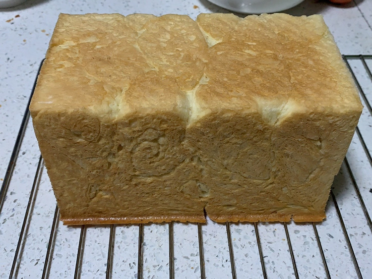 今天学做的吐司面包🍞🍞🍞我的烤箱温度高，150度烤40分钟，家里牛奶没了，我用宝宝的奶粉泡了一杯牛奶倒进去，我做了500g的面粉，多了就剩下的五个小吐司面包~吐了蜂蜜水在上面，放了果仁在里面，我喜欢放果仁到面包里！你们喜欢放什么？图1